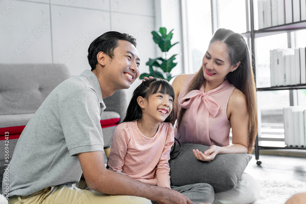 Asian family photo There are fathers, mothers and daughters. The father is the one holding the daughter. and having fun at home on the weekend Asian family photo There are fathers, mothers and daughters. The father is the one holding the daughter. and having fun at home on the weekend