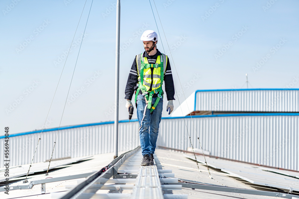Male engineer installing or checking the working condition of solar panels on the roof or at the height of the factory for saving electricity was broken to use renewable energy from the sun Male engineer installing or checking the working condition of solar panels on the roof or at the height of the factory for saving electricity was broken to use renewable energy from the sun