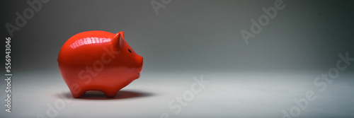 Rotes Sparschwein vor grauem Hintergrund photo