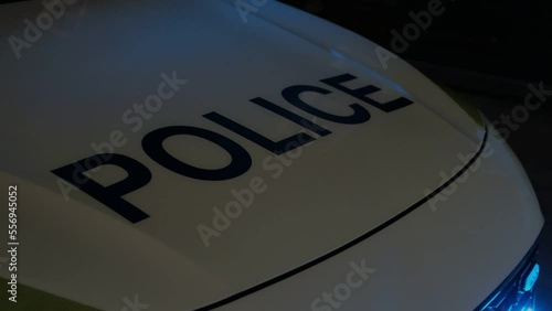 Late evening, night. British Police car, UK traffic police responding to road traffic accident. Emergency flashing lights.