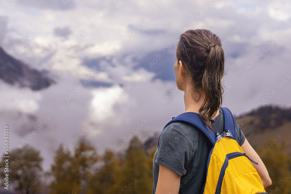 Woman standing on mountain slope looking at highland Woman standing on mountain slope looking at highland