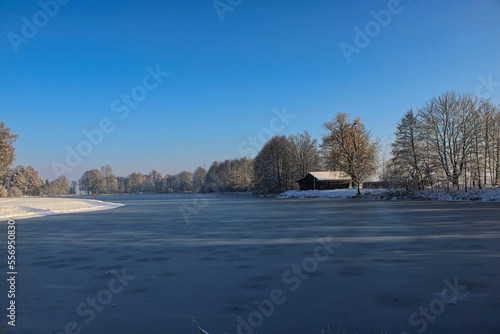 The frozen lake of Germering on a beautiful winter day in the early, quiet morning.  The lake is not much visited during this time and looks really calming to its visitors. photo