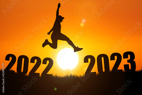 Happy New Year concept and change 2022 into 2023. Man jumping from 2022 to 2023.