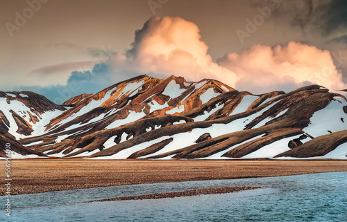 Landscape of volcanic mountain with snow covered and sunset sky among Icelandic Highlands on summer in Landmannalaugar at Iceland photo