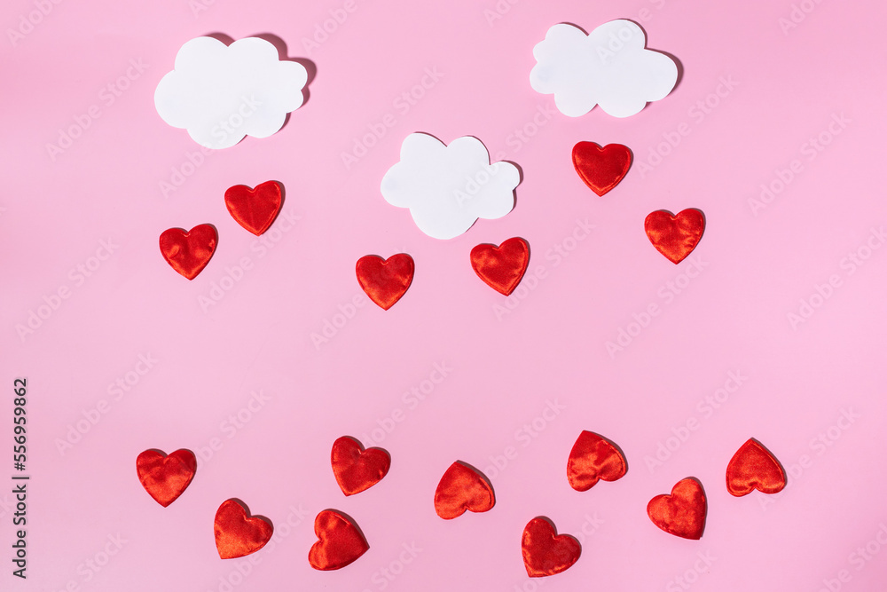 Paper white clouds with rain of red hearts. Conceptual background for Valentine's Day or Women's Day. Copy space