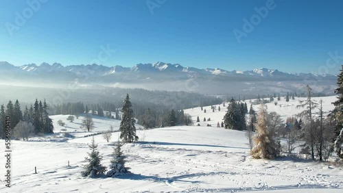 Epic alpine vista and white winter in the mountains. Aerial view of snow capped mountain landscape. Tatra high mountain range and magical unspoiled scenery with frozen spruce trees.
