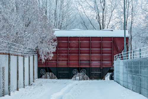 Cargo train rides through a snow covered railway line
