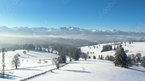 Epic alpine vista and white winter in the mountains. Aerial view of snow capped mountain landscape. Tatra high mountain range and magical unspoiled scenery with frozen spruce trees.