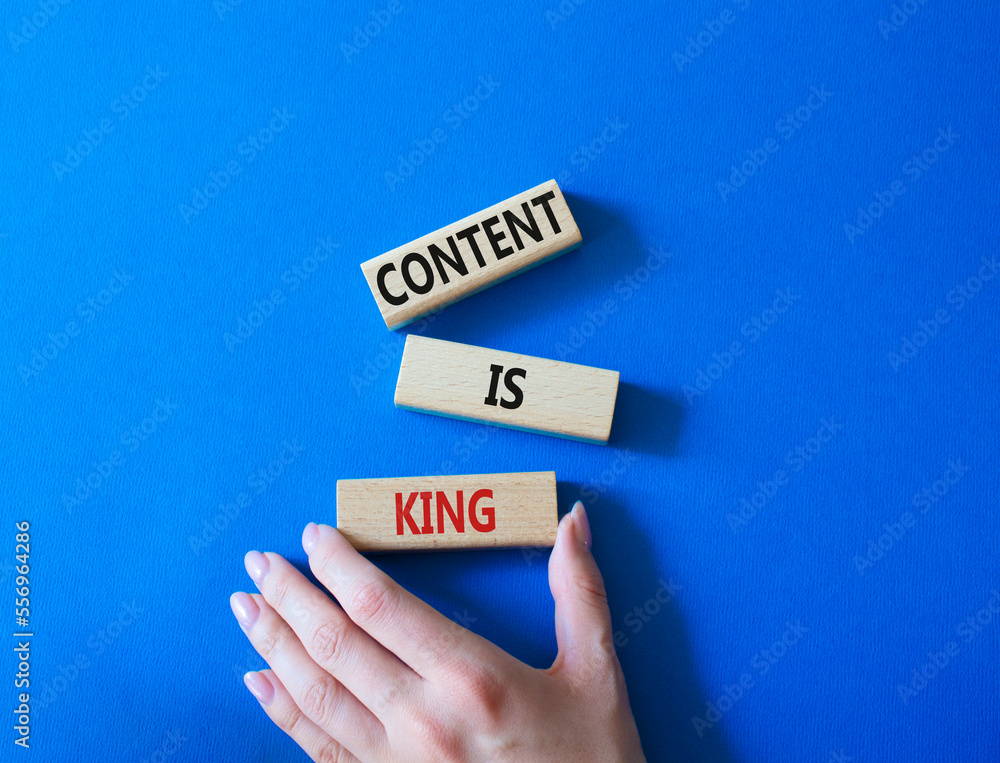 Content is king symbol. Concept words Content is king on wooden blocks. Businessman hand. Beautiful blue background. Business and Content is king concept. Copy space.