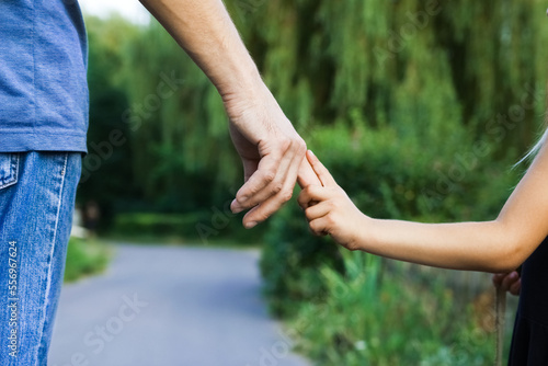 the parent holding the child's hand with a happy background