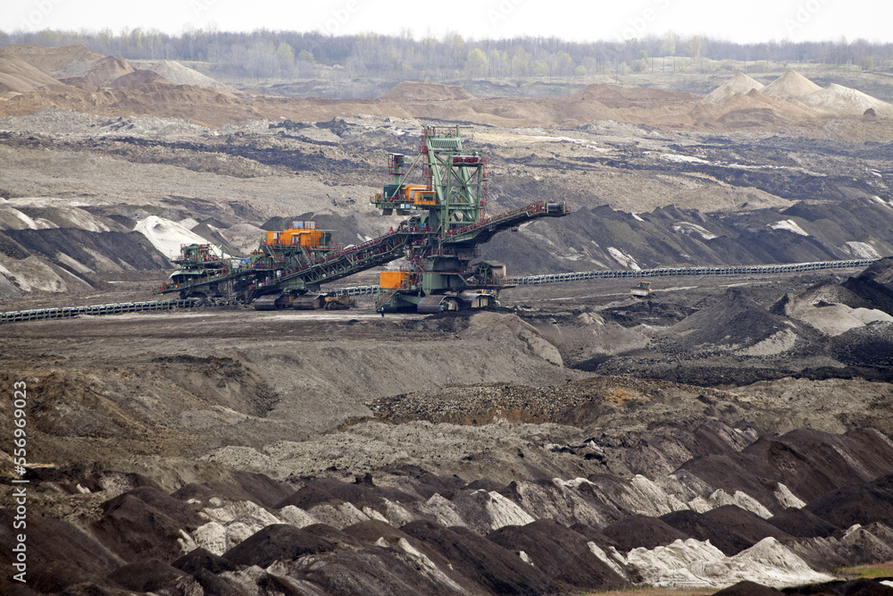 An huge excavator on a coal surface mine. Interesting geological forms of tailings dump in an open pit coal mine. An huge excavator on a coal surface mine. Interesting geological forms of tailings dump in an open pit coal mine.