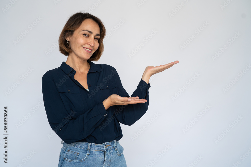 Satisfied woman holding something invisible. Female model in dark blue shirt showing something on hands. Portrait, studio shot, advertising concept Satisfied woman holding something invisible. Female model in dark blue shirt showing something on hands. Portrait, studio shot, advertising concept