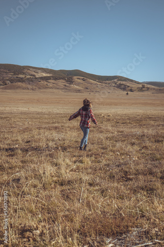 Woman Standing In Open Field With Mountains In The Background. Sunrise Highway, California. 