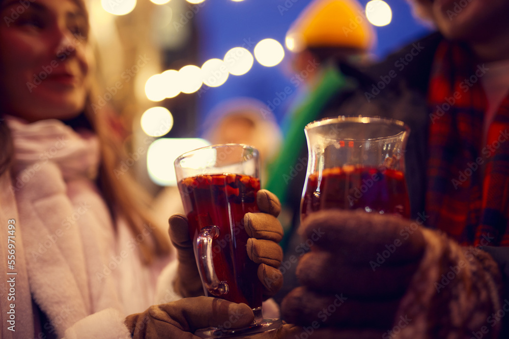 Close-up hands in mittens with mug of hot mulled wine. Happy holidays, national traditions, winter street fairs, Christmas concept. Close-up hands in mittens with mug of hot mulled wine. Happy holidays, national traditions, winter street fairs, Christmas concept.