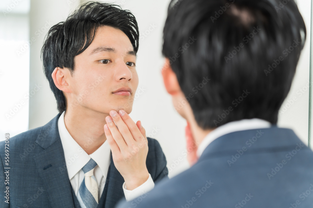 肌をチェックする若い日本人男性 肌をチェックする若い日本人男性