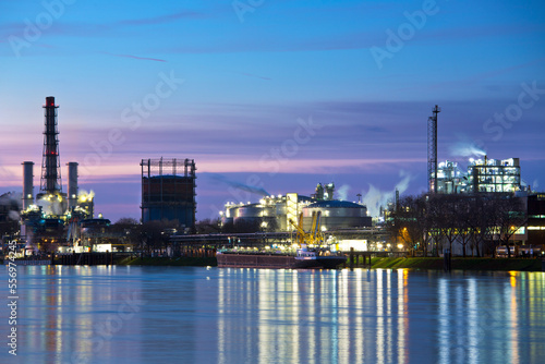 Part of a chemical plant by a river early in the morning