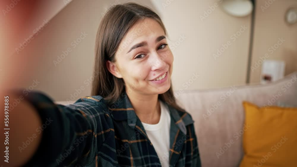 Smiling young caucasian woman vlogger make video call, looking at camera, recording vlog at home, talking. View from front camera to portrait video recording, girl holds mobile phone in hands. Smiling young caucasian woman vlogger make video call, looking at camera, recording vlog at home, talking. View from front camera to portrait video recording, girl holds mobile phone in hands.