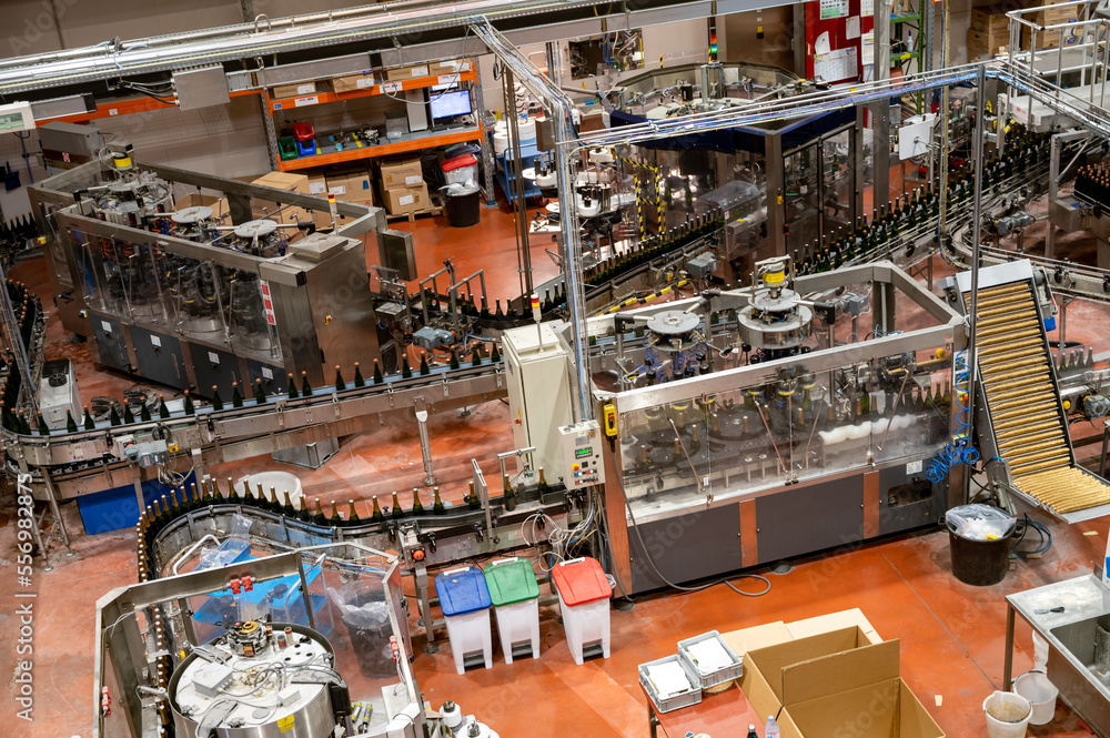 Obraz premium Production of cremant sparkling wine in Burgundy, France. Automatically powered bottling lines on factory.