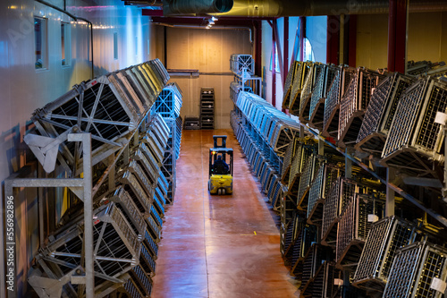 Production of cremant sparkling wine in Burgundy, France. Automatically powered riddling remuage boxes on factory.