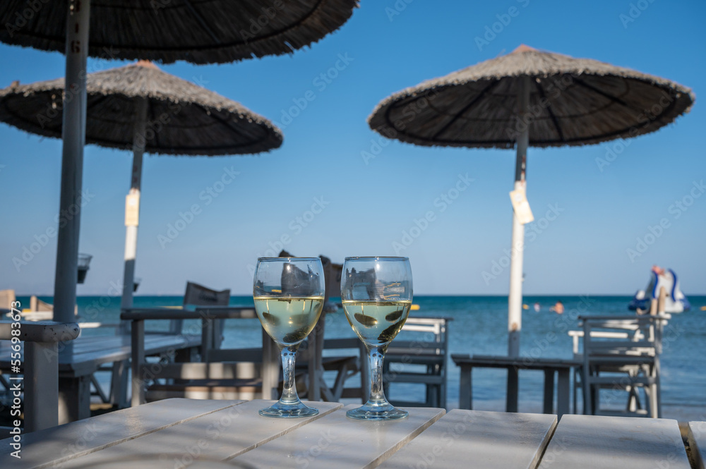 Drinking of cold white wine in beach bar, summer holidays, relax on sandy beach