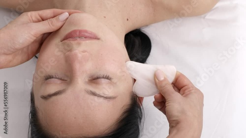 Beautiful young woman during traditional Chinese massage - Gua Sha