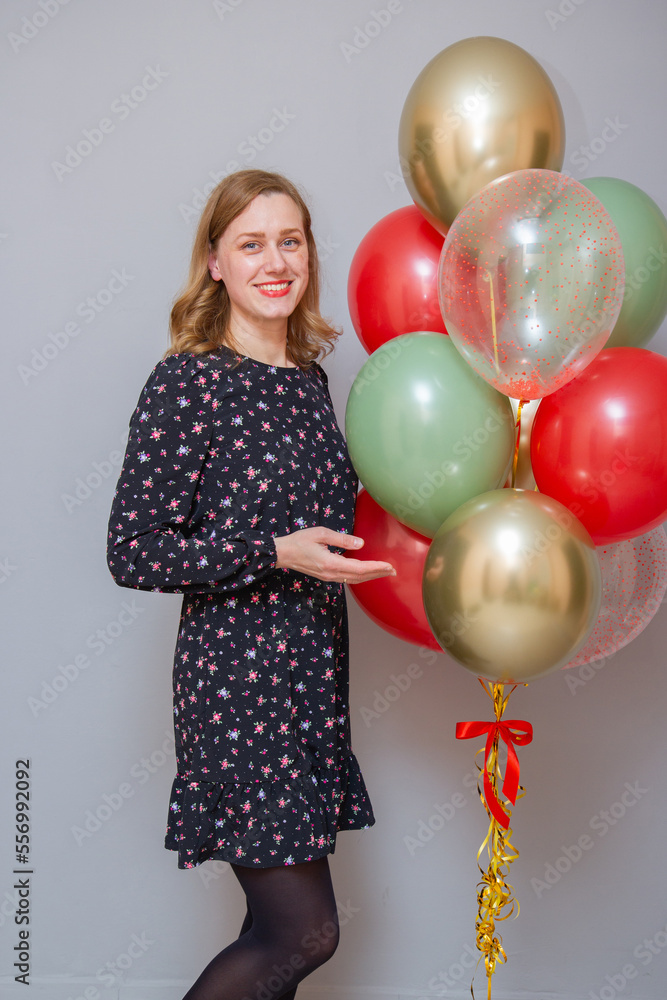 Fototapeta premium girl with red lipstick with a bunch of balloons against a gray wall