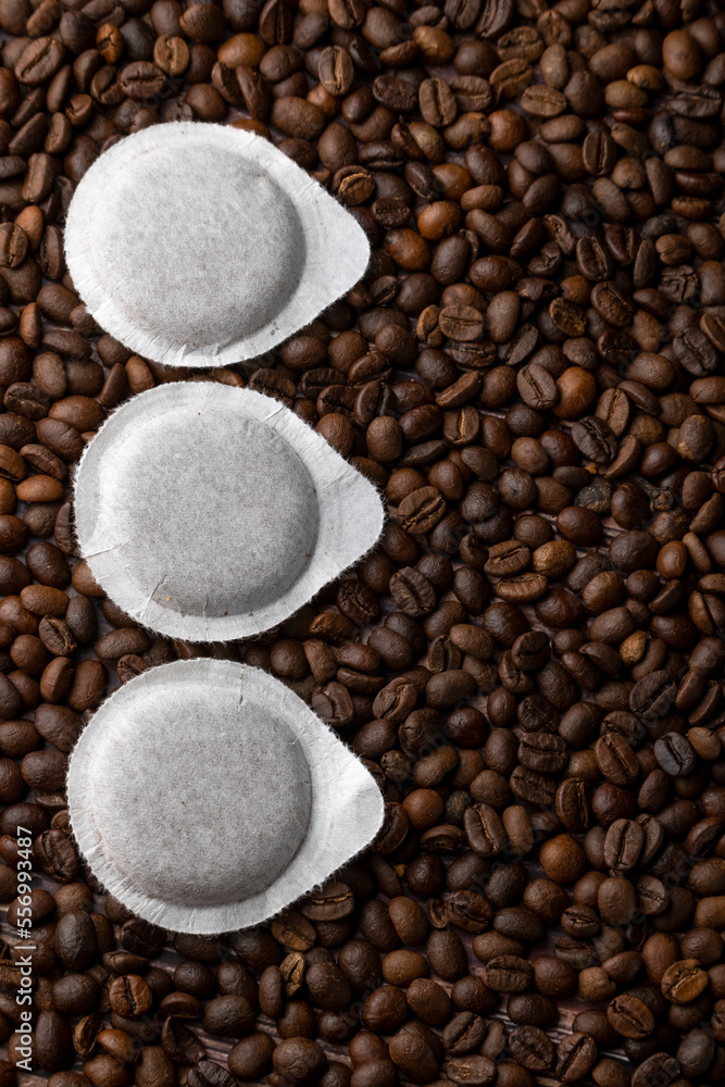 Fototapeta premium Paper pods for coffee machine on coffee beans background