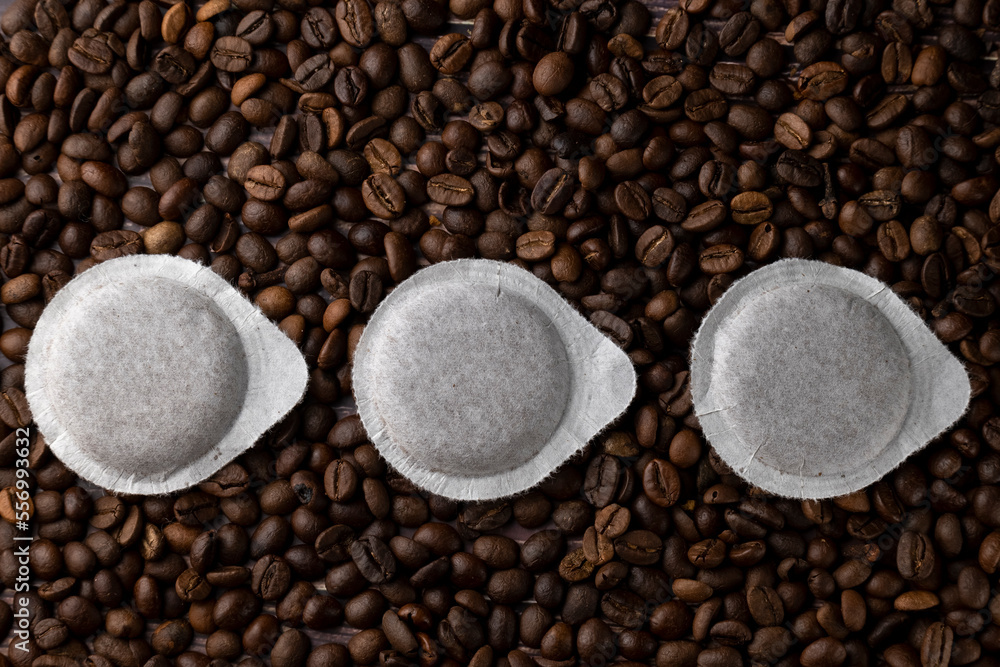 Fototapeta premium Paper pods for coffee machine on coffee beans background