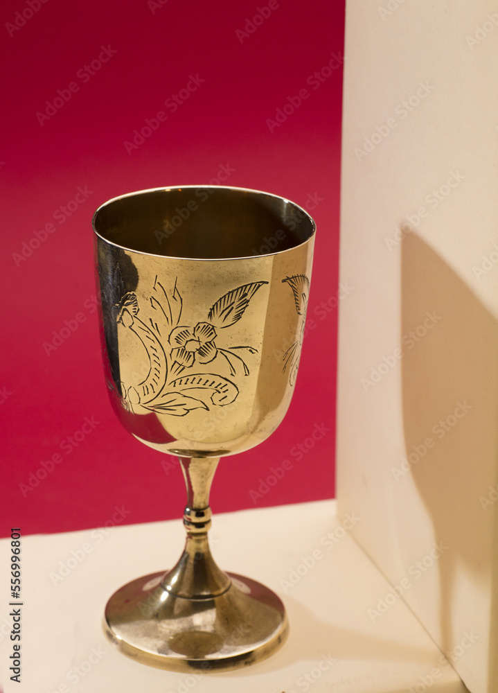 beautiful golden chalice on light beige bible with red background beautiful golden chalice on light beige bible with red background