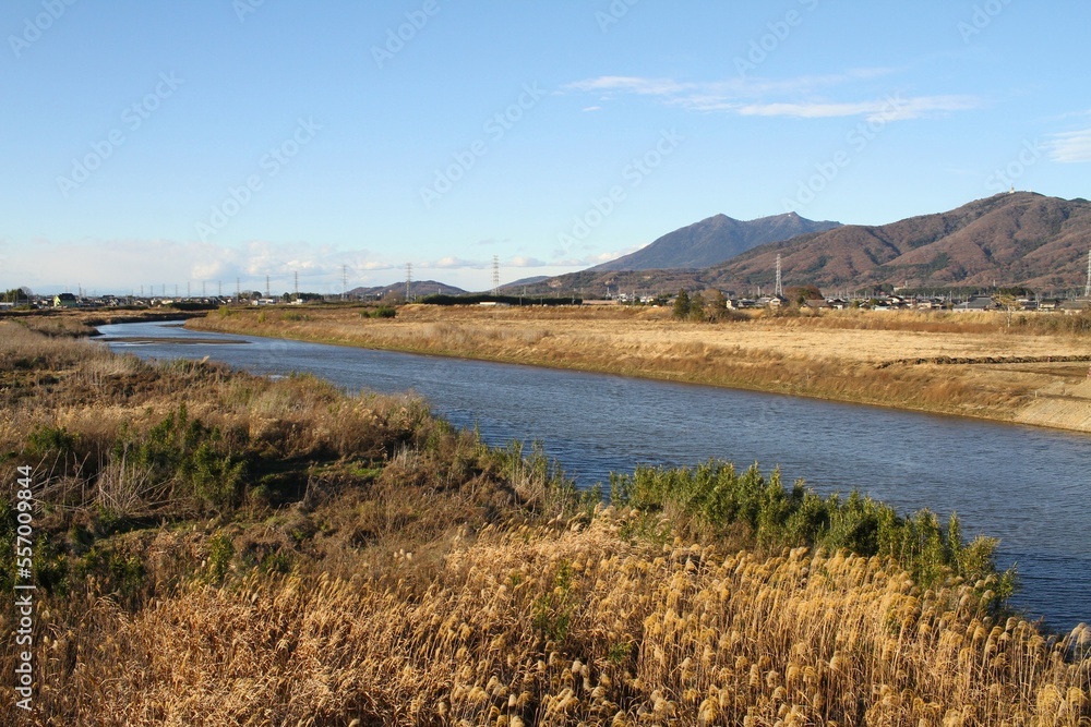 Beautiful Japanese Rural Landscape with a River running in front of a Mountains on a Clear Winter Afternoon