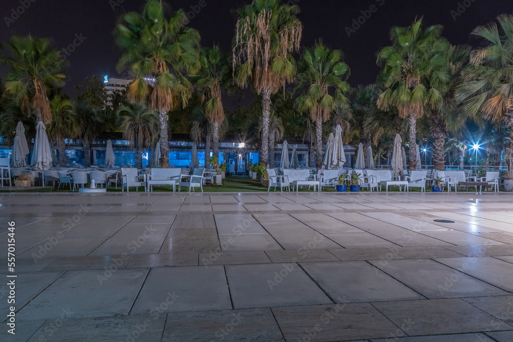 Public promenade in Malaga, Parmeral de las Sorpresas at late night in the full colors of the night city lights.  Modern urban architecture, Harbour quay at night.  Andalusia, Spain