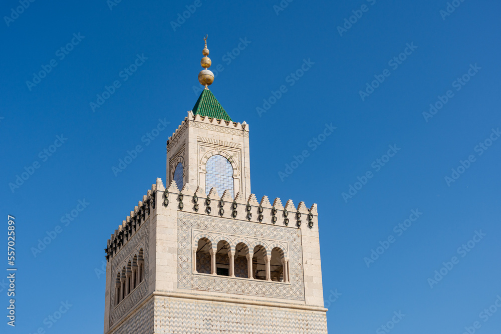 Close-up Ez-Zitouna Mosque minaret against a blue sky in the old city of Tunis. Famous Islamic landmark in Tunisia.