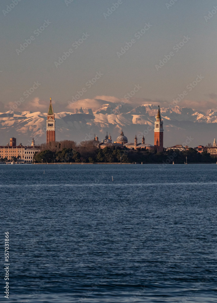 view of venice at sunset with st.mark's bell tower and dolomite mountains in the background