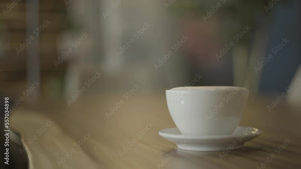 Cafe latte displayed in a white mug on a wooden table. Cafe latte displayed in a white mug on a wooden table.