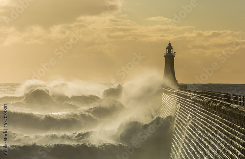 Big waves batter the lighthouse & north pier guarding the mouth of the Tyne in Tynemouth at sunrise, England
 photo