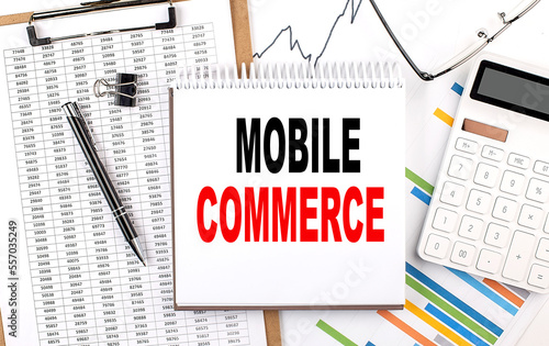 MOBILE COMMERCE text on notebook with chart, calculator and pen