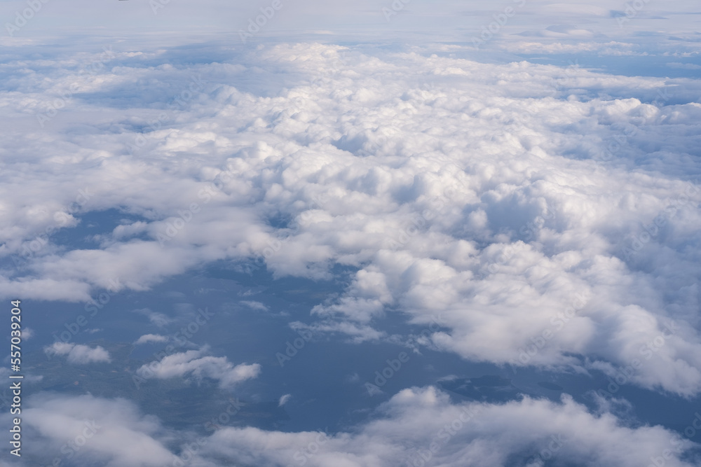 The view from the plane window to the clouds and the ground. The landscape of the earth's surface The view from the plane window to the clouds and the ground. The landscape of the earth's surface