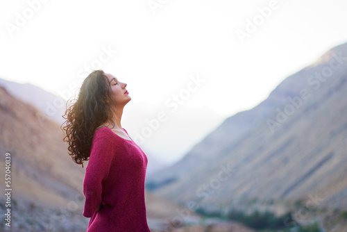 latin woman in a meditative state with eyes closed, head raised and arms behind the back enjoying the sunset in Cochiguaz , Valle del Elqui photo