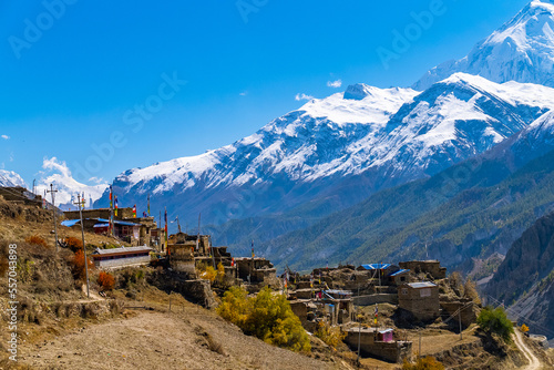 Fototapeta Small high altitude village with snowy Annapurna mountain range in the distance,