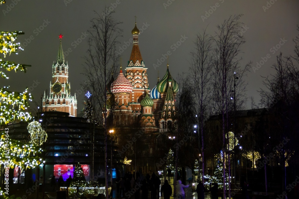 Christmas decorations on winter Red Square in Moscow, Russia. Illuminated St. Basil's Cathedral and tall Christmas tree. Evening cityscape with bright night lights. New Year celebration.