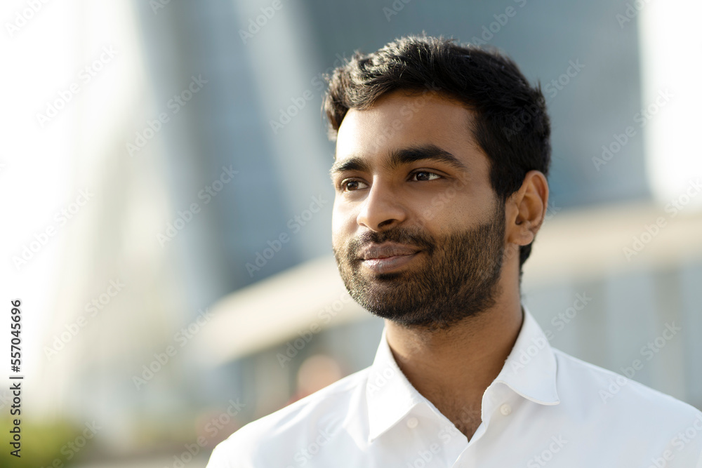Portrait of handsome confident Indian businessman wearing white shirt looking away on the street. Successful business concept Portrait of handsome confident Indian businessman wearing white shirt looking away on the street. Successful business concept