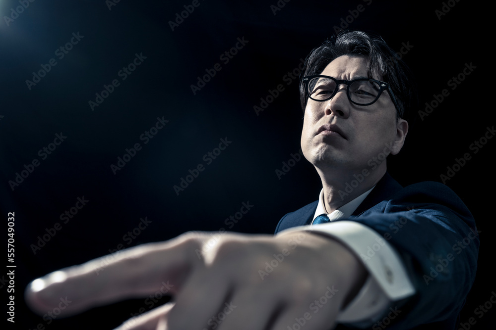 Obraz premium 指を差して偉そうに指示をしているビジネスマンのミドル男性
