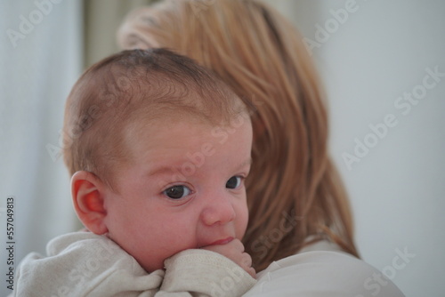 Mother with her newborn baby. Mother is holding her little baby boy. Baby on mom's shoulder. 