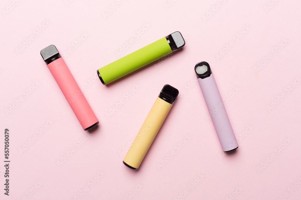 Disposable electronic cigarettes on color background, top view Disposable electronic cigarettes on color background, top view