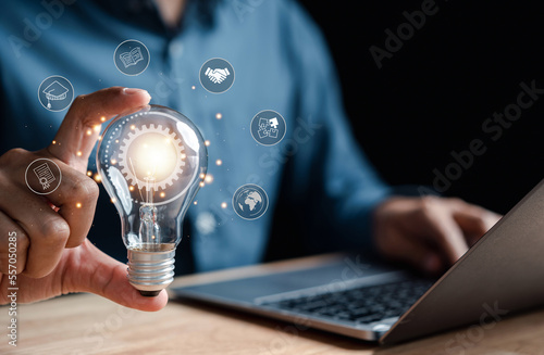 Man hand holding lightbulb with learning educate and graduation concept. study knowledge to creative thinking idea and problem solving solution, E-learning online education course degree certificate