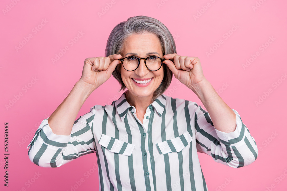 Portrait photo of old pensioner business lady cheerful smile touch her glasses good vision after correction isolated on pastel pink color background Portrait photo of old pensioner business lady cheerful smile touch her glasses good vision after correction isolated on pastel pink color background