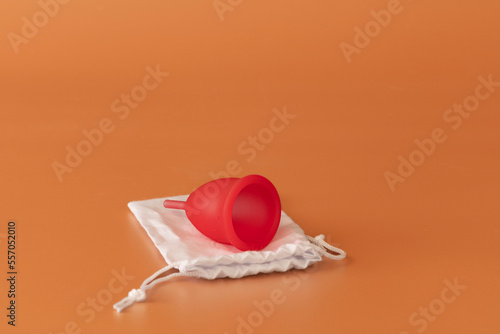 A red menstrual cup in neutral background. Alternative ecological method for woman.  During Menstrual cycle.  photo