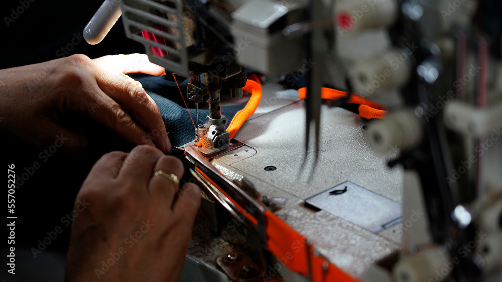tailor is sewing fabric on the sewing machine tailor is sewing fabric on the sewing machine
