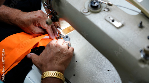tailor is sewing fabric on the sewing machine