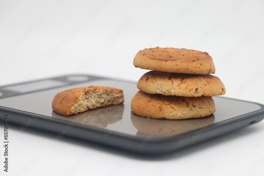 A pack of cookies on an electronic kitchen scale, accurate calorie counting, proper nutrition, diet. A pack of cookies on an electronic kitchen scale, accurate calorie counting, proper nutrition, diet.